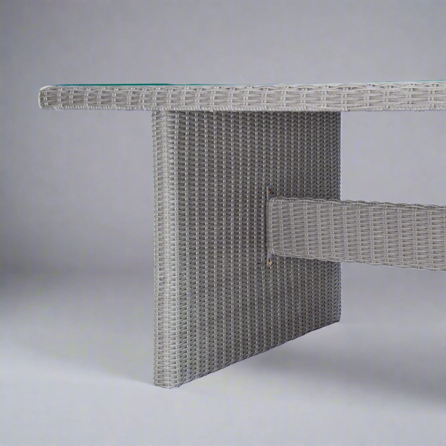Grey outdoor poly rattan wicker dining table detail with glass top, modern patio furniture