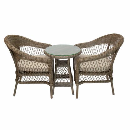 A 3-piece outdoor wicker furniture set featuring two armchairs with cream cushions and a small round side table with a gray stone-look top, isolated on a white background.