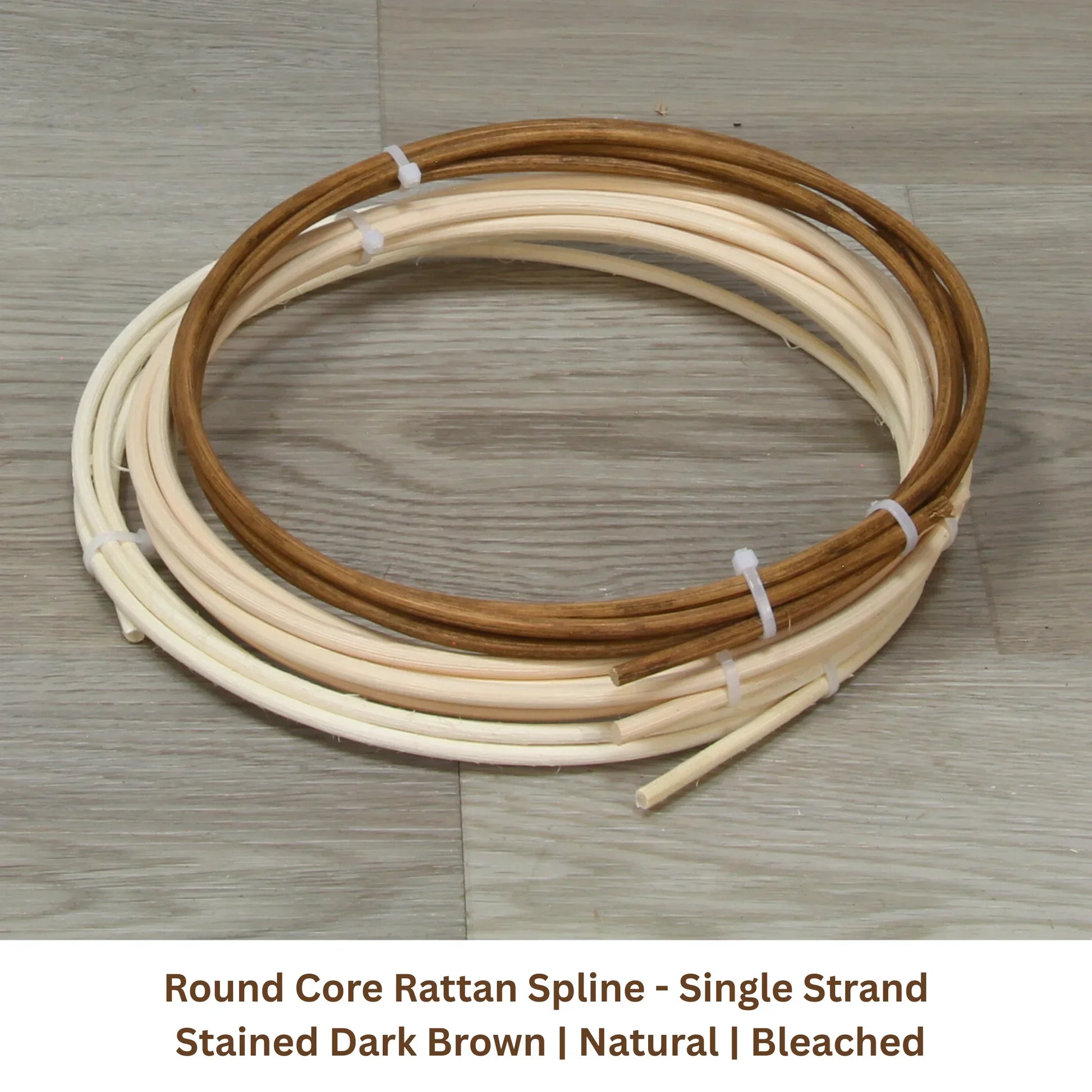 Round core rattan spline strands in natural and dark brown, coiled on wooden floor