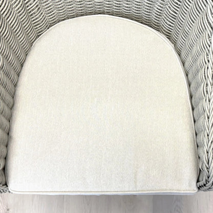 Cream cushion on grey woven rattan chair, outdoor wicker furniture detail
